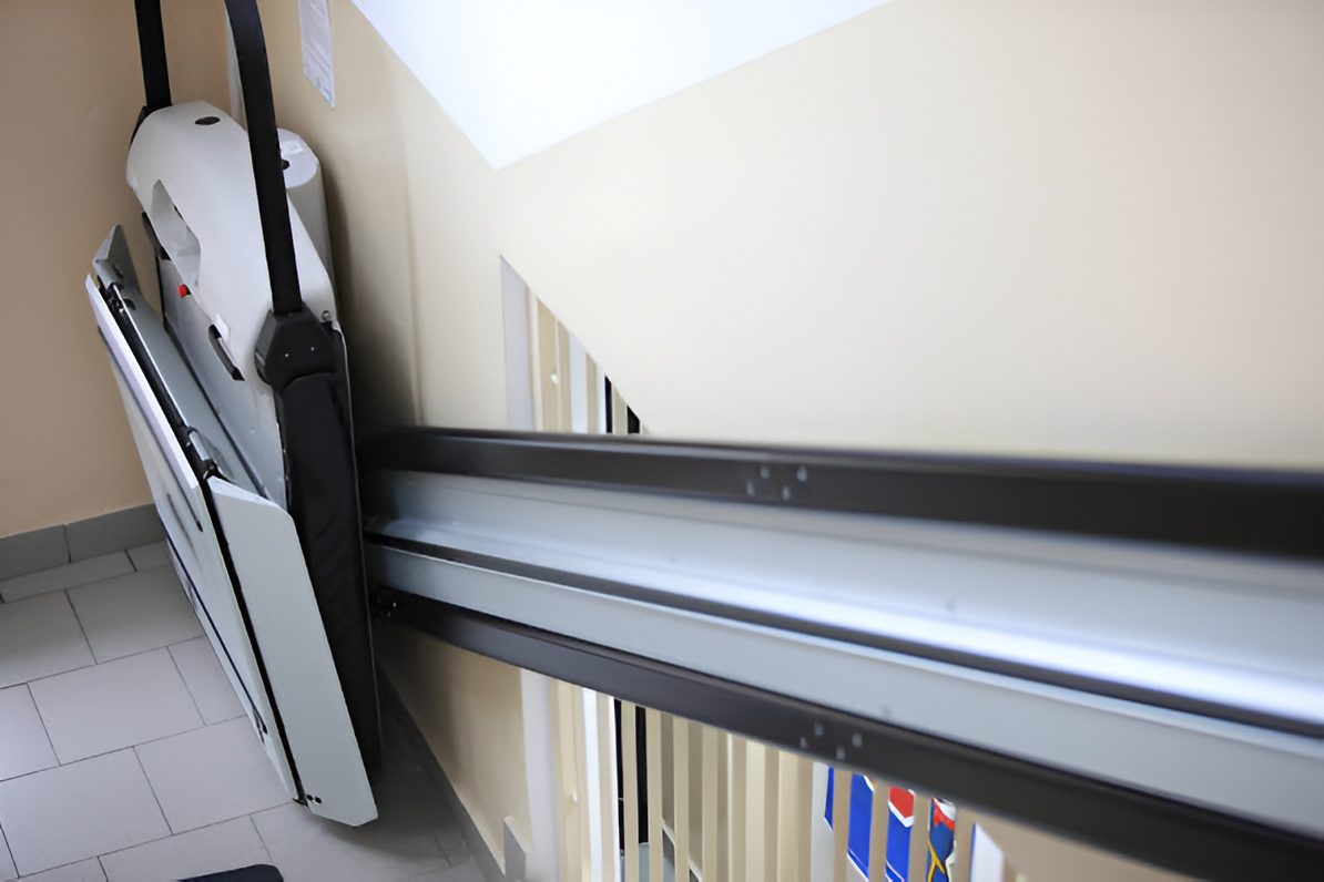 Folded platform stairlift mounted on stair rail